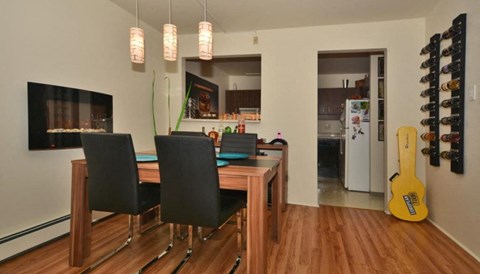 a dining room with a table and a guitar on the wall