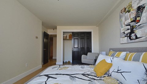 a bedroom with a bed and a living room with a couch