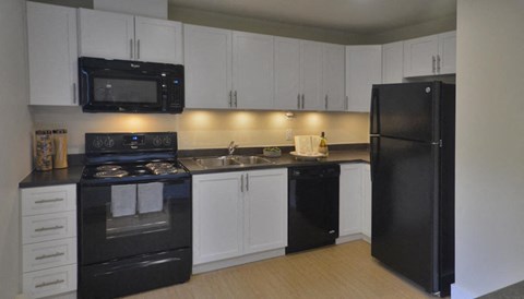 a kitchen with black appliances and white cabinets