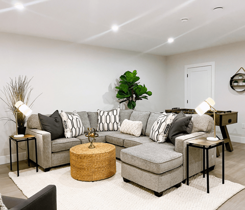 A living room with a grey sofa and a wicker coffee table.