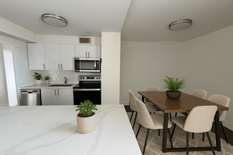 A kitchen with a dining table and chairs.