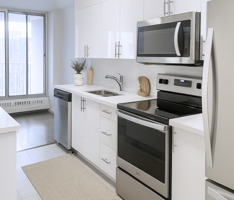 A modern kitchen with stainless steel appliances and white cabinetry.