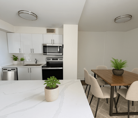 A kitchen with a dining table and chairs.