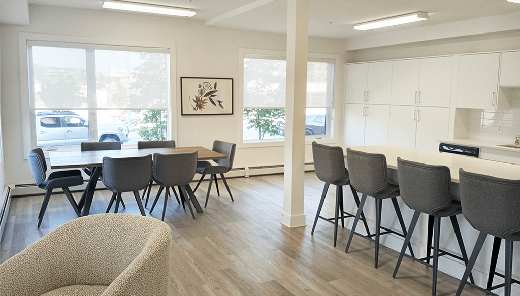 a conference room with tables and chairs and a kitchen