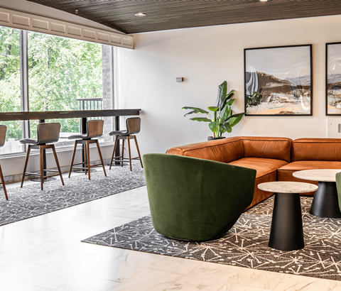 A living room with a green chair and a brown couch.