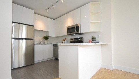 a kitchen with white cabinets and a stainless steel refrigerator