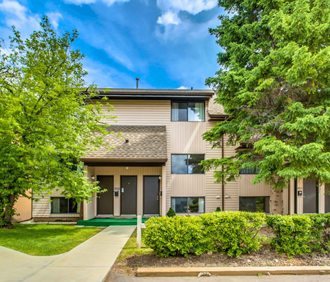 A modern two-story building with a green lawn in front.