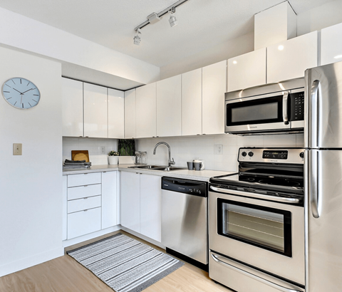 A modern kitchen with stainless steel appliances and white cabinets.