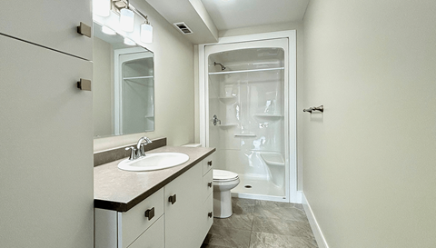 A bathroom with a sink, toilet and shower.