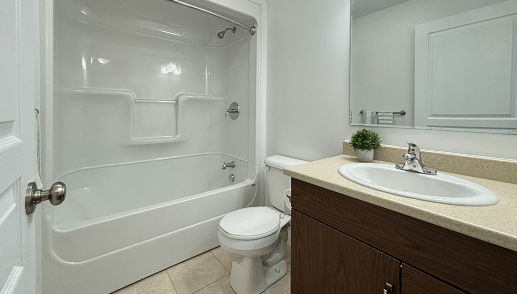 A white bathroom with a toilet, sink, and tub.