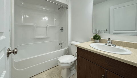 A white bathroom with a toilet, sink, and tub.