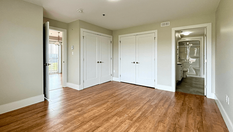 A room with wood flooring and white walls.