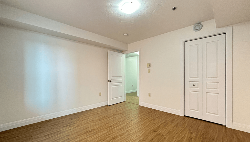 A room with a white door and a white wall.