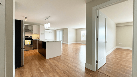 A kitchen with a refrigerator, oven, and sink is shown.