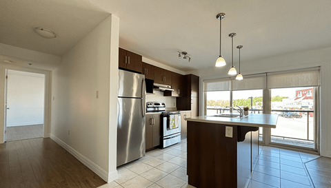 A modern kitchen with stainless steel appliances and a wooden island.