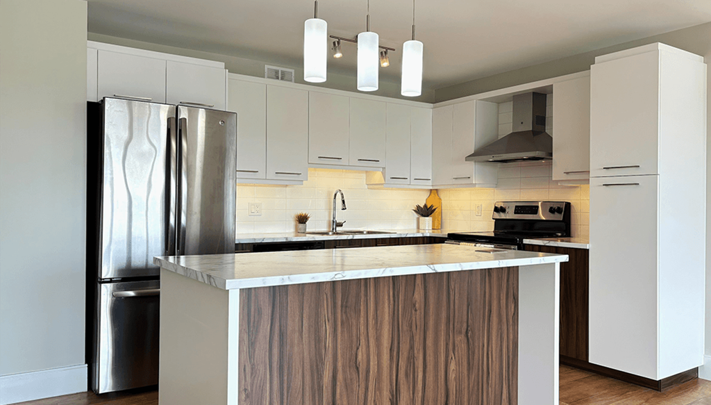 A modern kitchen with a stainless steel refrigerator and wooden island.