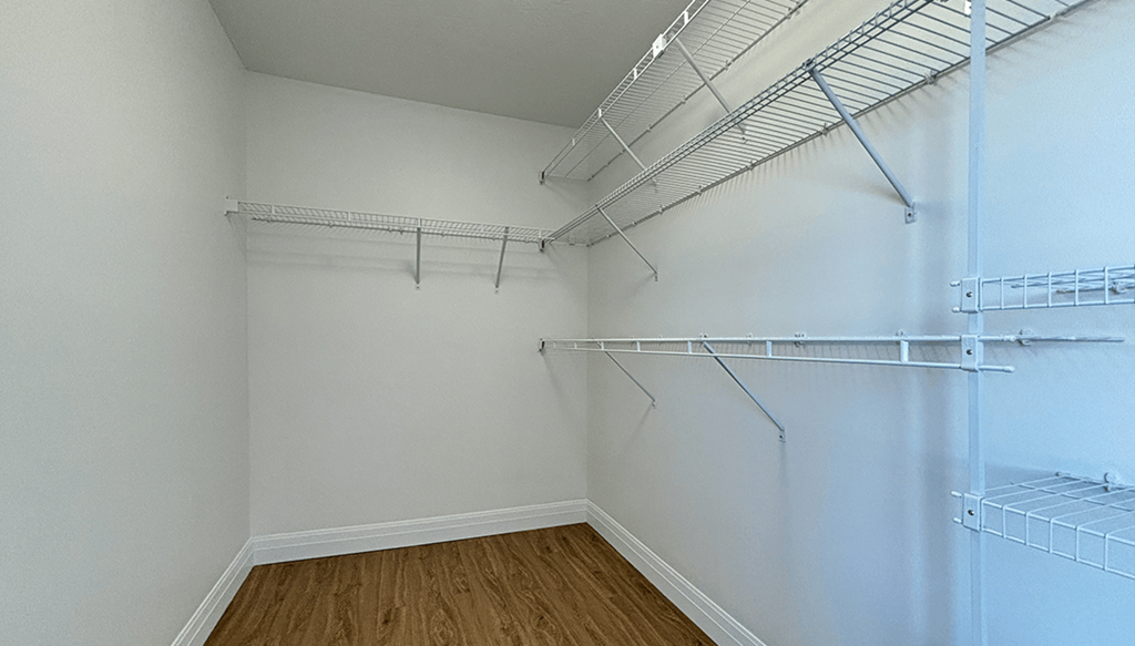 Empty room with white walls and wooden floor.