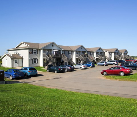 A parking lot with cars and apartment buildings in the background.