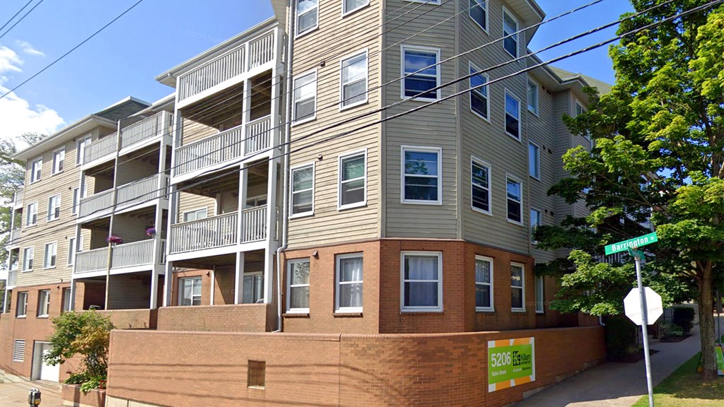 an apartment building with a street sign in front of it