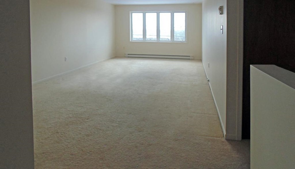 an empty living room with a window in it