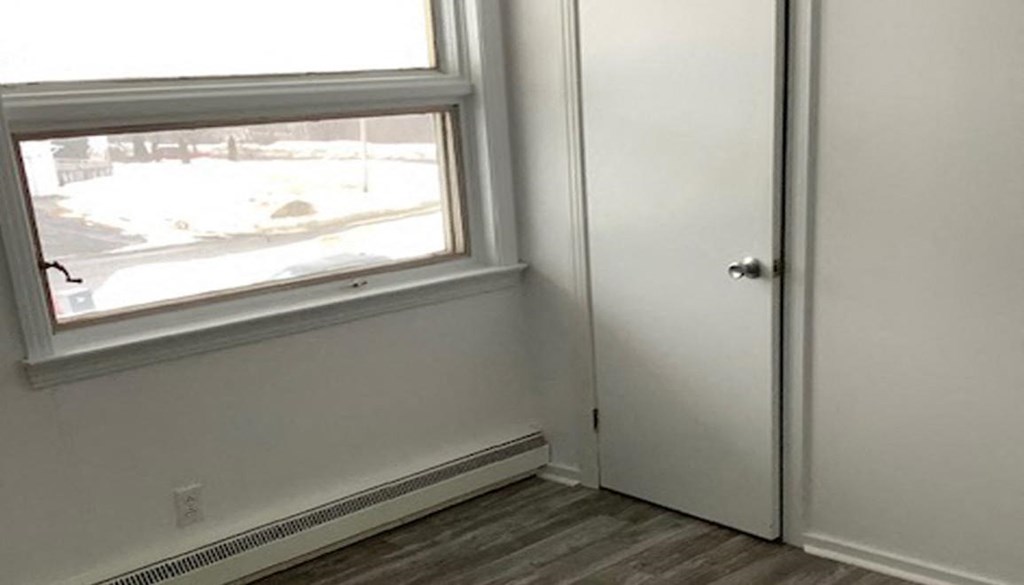a white room with a window and a door