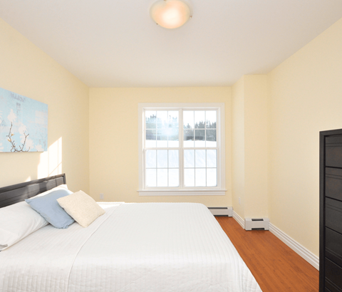 A bedroom with a large bed and a window.