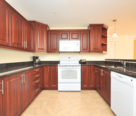 A kitchen with brown cabinets and a white stove top oven.