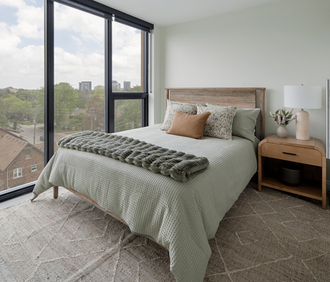 A bedroom with a large bed and a view of the city.