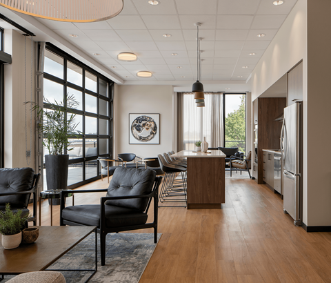 A modern living room with black leather chairs and a wooden coffee table.