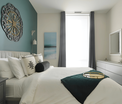 A bedroom with a white bed and a blue wall.
