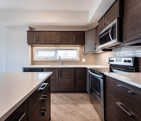 A modern kitchen with dark wood cabinets and stainless steel appliances.
