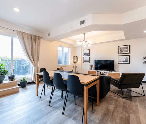 A modern dining room with a wooden table and chairs.
