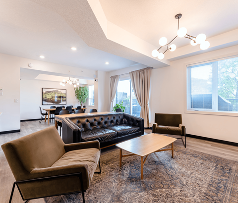 A living room with a black couch, brown armchair, and a wooden coffee table.