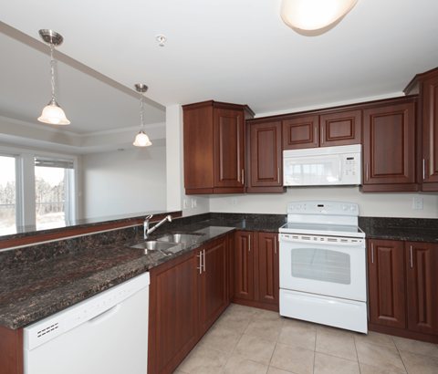 A kitchen with brown cabinets and white appliances.