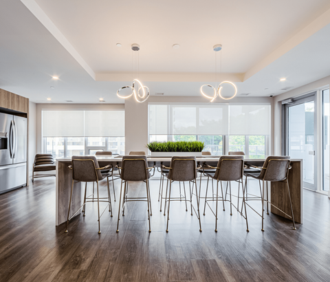 A modern dining room with a long table and chairs.