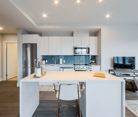 A modern kitchen with white cabinets and a central island.