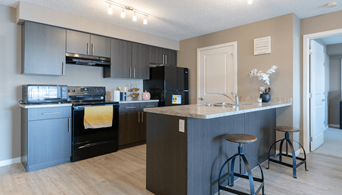 a kitchen with an island and a stove and a refrigerator