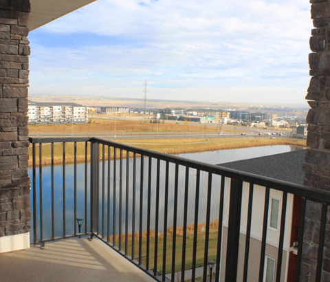 A balcony with a view of a field and buildings.