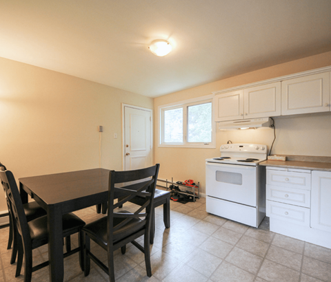 A kitchen with a table and chairs.