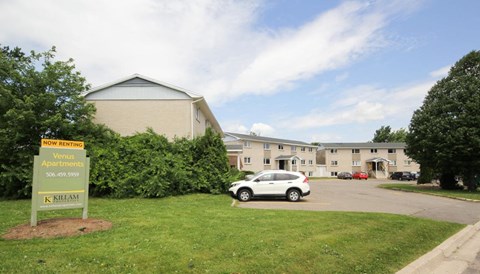 a car parked in a parking lot in front of an apartment building