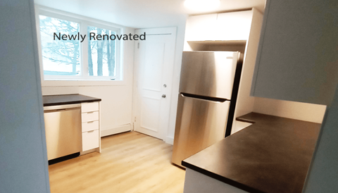 a small kitchen with a refrigerator and a window