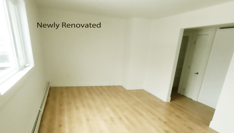an empty room with white walls and wooden floors