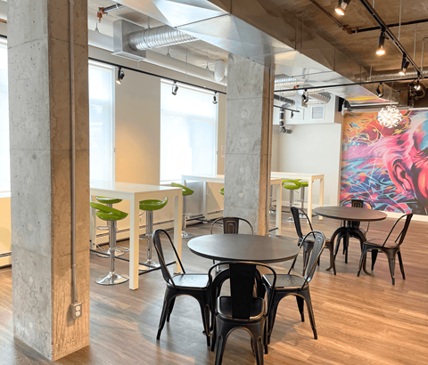 A modern dining area with a large mural on the wall.