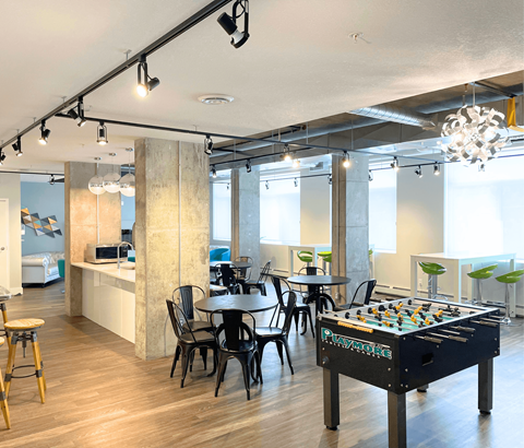 A room with a pool table and a bar area.