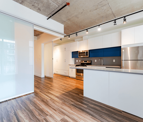 A kitchen with white cabinets and a blue accent wall.