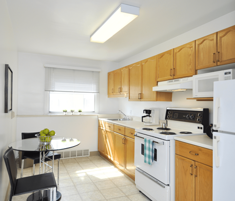 A kitchen with a white stove top oven and white refrigerator.