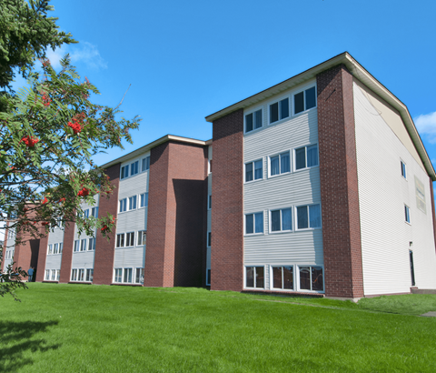 A red and white building with a green lawn in front.