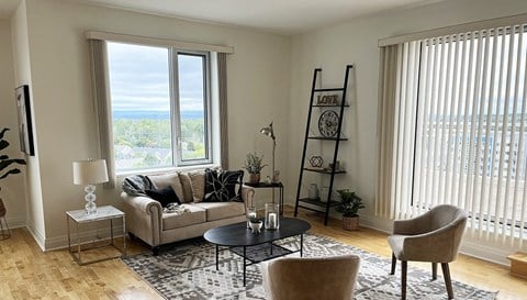 a living room with a couch and a table and two windows