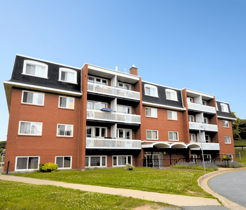 A red brick apartment building with white trim and balconies.