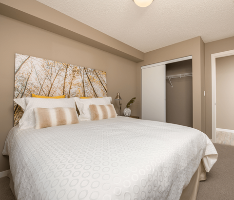 A bedroom with a large bed and a painting on the wall.